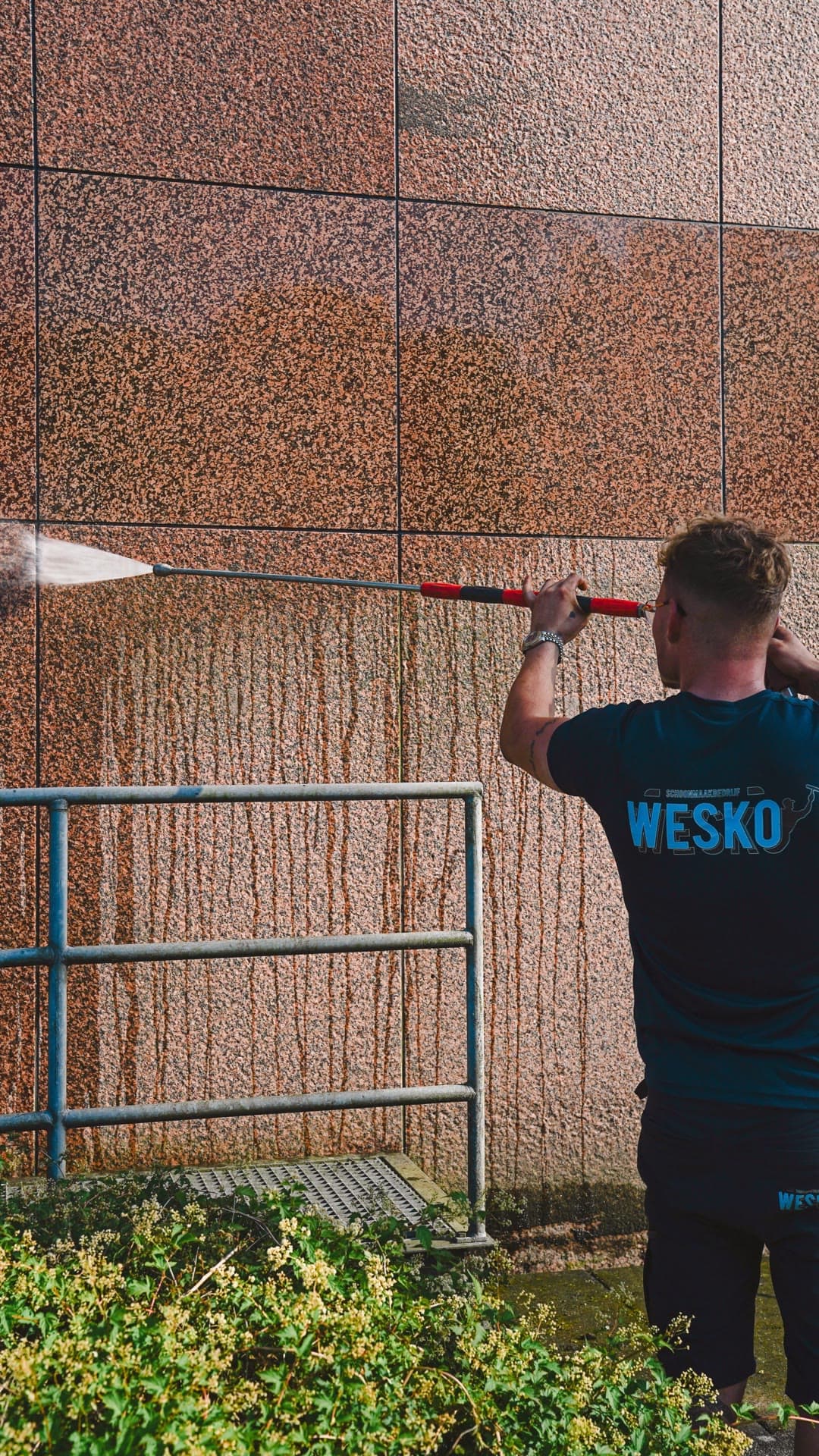 Wesko-medewerker reinigt een gevel met een telescoopsteel in Groningen.
