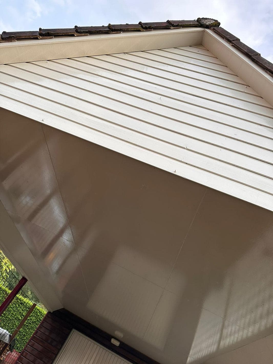 Dezelfde witte gevelpanelen met een schoner oppervlak na de reiniging.