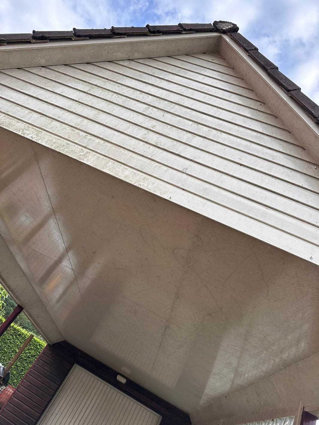Witte gevelpanelen met zichtbare vervuiling vóór de reiniging.