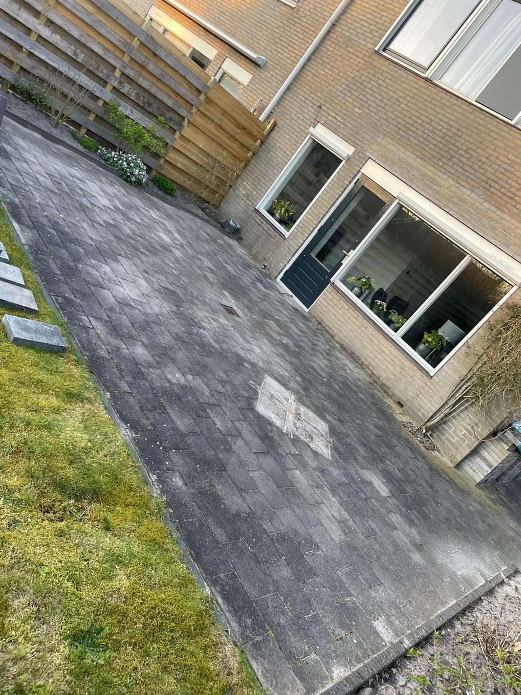 Betegeld terras met donkere aanslag vóór de reiniging.